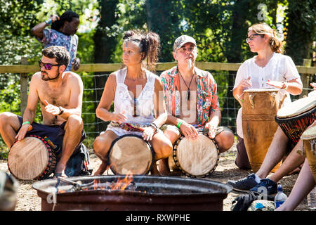 Festivaliers assistent à un atelier de percussion en plein air dans les bois à l'état sauvage festival, Kent, UK Banque D'Images