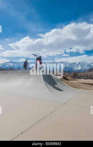 Jeune skateur professionnel faisant des tours à un skate parc à Lone Pine, en Californie. Banque D'Images