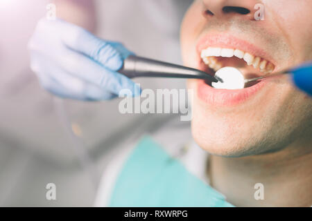 Portrait d'un dentiste qui traite les dents de jeune homme patient. Banque D'Images