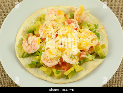 Tostado de crevettes par des tranches d'avocat et de tomate et fromage fondu on white plate Banque D'Images