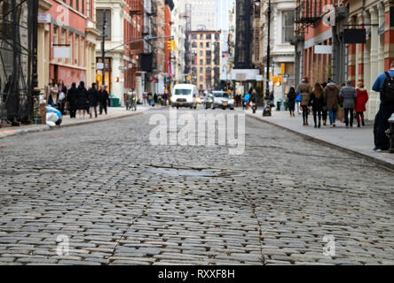 Avis de cobblestone couverts Greene Street avec la lumière du soleil dans l'arrière-plan le quartier de SoHo à Manhattan, New York City Banque D'Images