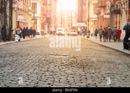 Avis de cobblestone couverts Greene Street avec la lumière du soleil dans l'arrière-plan le quartier de SoHo à Manhattan, New York City Banque D'Images