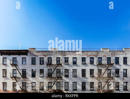 Vue panoramique ancien immeuble en brique blanche avec windows et le feu s'échappe et un fond de ciel bleu au-dessus de la ville de New York NYC Banque D'Images