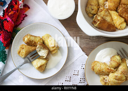 Crêpes maison farcies au fromage blanc et aux raisins secs, servi avec crème sure et cerise. Moldave traditionnelle roumaine ou dessert, fo sélective Banque D'Images