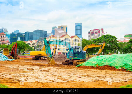 Site de construction et machines excavatrices creusant travaillant sur la rue du centre-ville de Singapour Banque D'Images