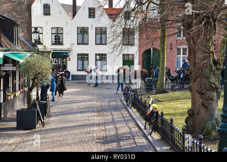 BRUGES, BELGIQUE - 17 février 2019 : place avec les touristes, les chevaux avec chariots, des bâtiments historiques Banque D'Images