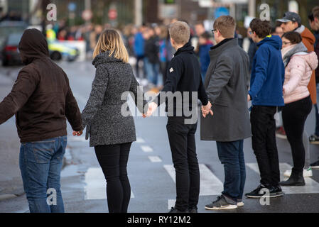 11 mars 2019, Bade-Wurtemberg, Winnenden : Les élèves sont debout dans une chaîne humaine au cours de la cérémonie de commémoration du 10ème anniversaire du Winnenden amok run. Le 11 mars 2009, un ancien étudiant tourné 15 personnes dans l'école secondaire d'Albertville et pendant le vol subséquent. Photo : Sebastian Gollnow/dpa Banque D'Images