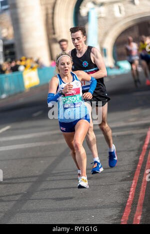Purdue Charlotte d'exécution dans la grande vitalité de la moitié demi-marathon traversant le Tower Bridge, Londres, Royaume-Uni. Banque D'Images