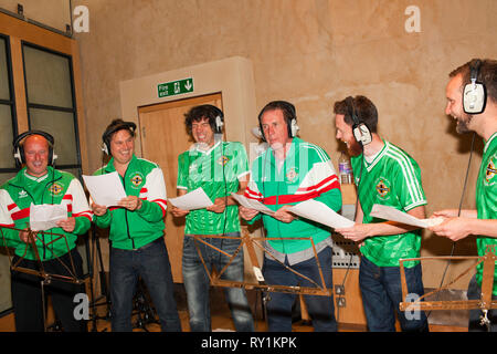 Snow Patrol chantant avec d'anciens footballeurs d'Irlande Gerry Armstrong et David Campbell. Banque D'Images