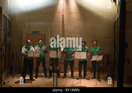 Snow Patrol chantant avec d'anciens footballeurs d'Irlande Gerry Armstrong et David Campbell. Banque D'Images