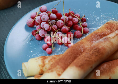 Crêpes aux fruits rouges, confiture, miel et chocolat, saupoudré de sucre en poudre et la cannelle Banque D'Images