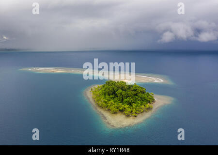 Une superbe île tropicale est entourée de récif en Papouasie Nouvelle Guinée. Cette région fait partie du Triangle de corail en raison de sa biodiversité marine. Banque D'Images