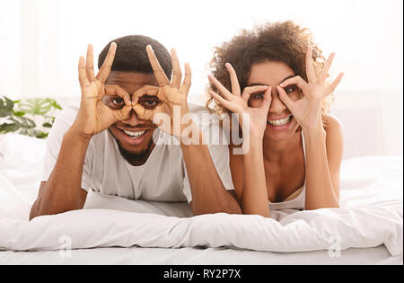 Cheerful couple heureux en amour holding doigts près de yeux Banque D'Images