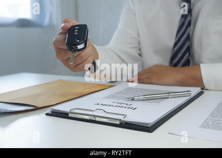 Close-up part donner une clé de voiture après avoir signé un document de location de voiture, assurance voiture. Banque D'Images