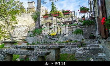 Un vélo accroché sur la clôture de la tour avec quelques pots de fleurs et plantes sur le terrain Banque D'Images