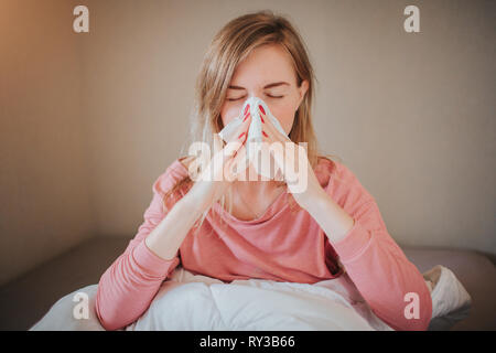 Photo d'une jeune femme avec un mouchoir. Sick girl a le nez. modèle féminin fait un remède pour le rhume. Le patient est allongé dans le lit Banque D'Images