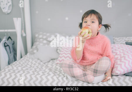 Petite fille mange une pomme Banque D'Images