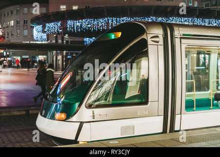 STRASBOURG, FRANCE - DEC 23, 2016 ; Tramway à nuit en français Ville de Strasbourg avec les piétons et les lumières des décorations de Noël de flou artistique en arrière-plan Banque D'Images