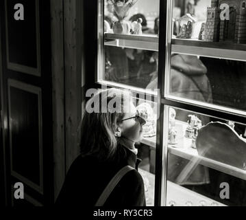 Woman admiring les cadeaux de Noël de souvenirs par les fenêtres du chalet du Marché de Noël à Strasbourg Alsace, atmosphère Banque D'Images