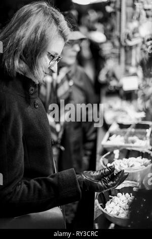 L'achat de souvenirs et jouets femme réalisés à la main à partir de laine au traditionnel marché de Noël à Strasbourg Alsace Banque D'Images