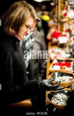 L'achat de souvenirs et Femme tenant à la main des jouets en tissu de laine au traditionnel marché de Noël à Strasbourg Alsace Banque D'Images