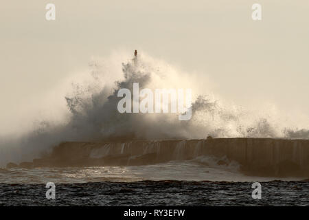 Grosse Vague contre phare dans le nord du Portugal dans un ciel couvert soir orageux - embouchure de la rivière Ave à Vila do Conde Banque D'Images