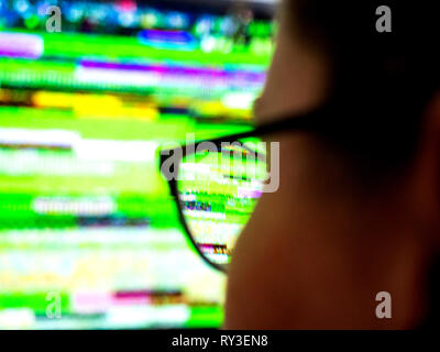 Vue arrière de l'optique lunettes femme portant à la recherche au mauvais signal bruit statique de son écran de télévision TVN numérique Banque D'Images