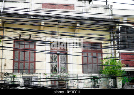 Câblage électrique en désordre, un enchevêtrement de câbles de masse exposés dans une rue de Hanoi, Vietnam Banque D'Images