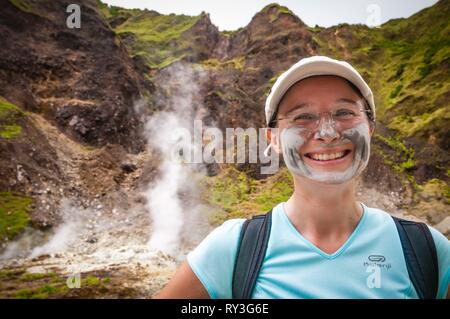 La Dominique, Parc national du Morne Trois Pitons inscrits sur la Liste du patrimoine mondial par l'UNESCO, vallée de la désolation, randonneur portant un masque d'argile pure, au milieu des fumerolles et hot springs Banque D'Images