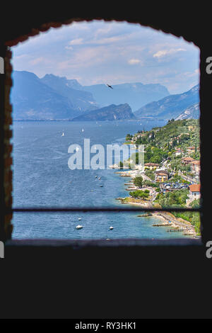 Vue sur le lac de Garde dans un vieux cadre en bois fenêtre. Le format Portrait. Banque D'Images