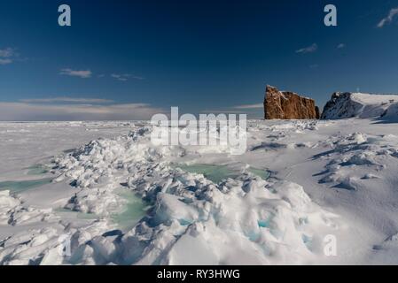 La glace de mer d'hiver avec le majestueux rocher Percé à l'arrière-plan. Banque D'Images