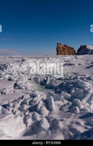 La glace de mer d'hiver avec le majestueux rocher Percé à l'arrière-plan. Banque D'Images