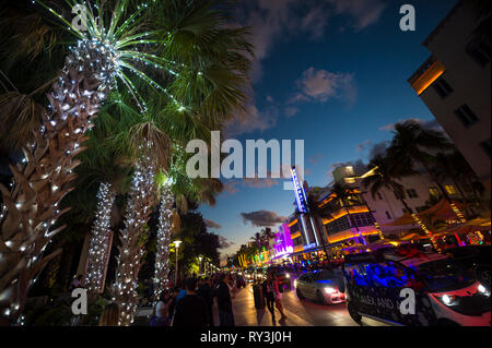 MIAMI - 30 décembre 2018 : Les visiteurs se promener le long de la lumières de Ocean Drive, avec néons et Art déco maison de palmiers décorés pour Noël. Banque D'Images