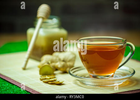 Jus de gingembre dans une tasse de miel clair et pot placé à côté avec un ruban à mesurer. Concept de santé. Banque D'Images