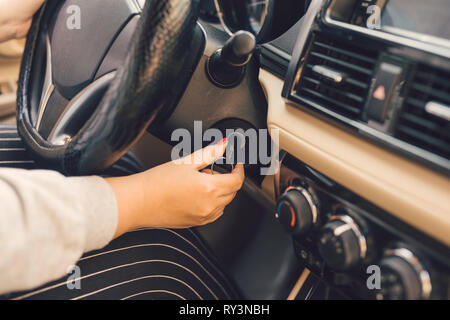 Femme part mettre la clé dans le contact et démarre le moteur de la voiture Banque D'Images