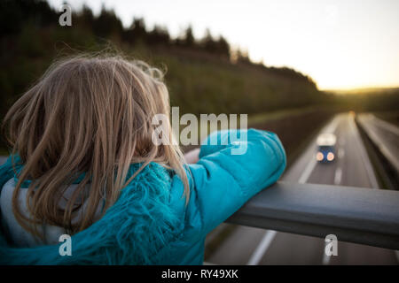 Enfant regardant le trafic d'un pont de l'autoroute Banque D'Images