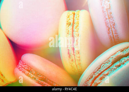 Macarons colorés sur fond bleu foncé. Vue de dessus, Close up, tonique avec effet 3D à la mode. Banque D'Images