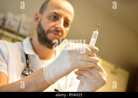 La préparation d'un médecin et d'injection en portant des gants protecteurs Banque D'Images