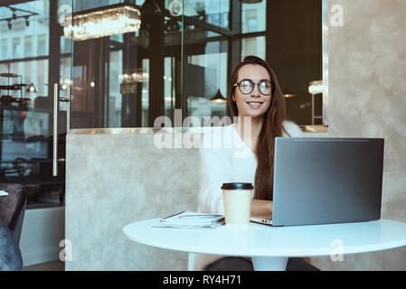 Femme entrepreneur travaillant de cafe et talking on mobile phone Banque D'Images