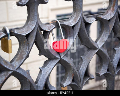 En forme de coeur rouge cadenas verrouillé sur une rampe en fer forgé Banque D'Images