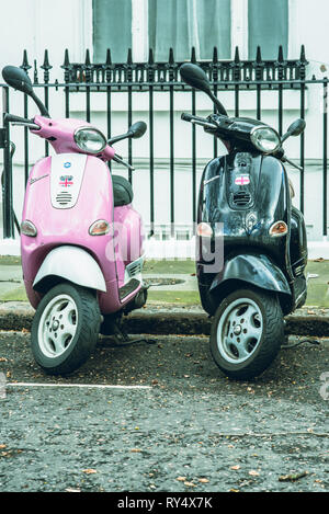 Belgravia, London, UK - Mars 2019 : une rose et noir essence alimenté scooter garé dans un parking à l'extérieur de la baie les riches parties de Londres Banque D'Images
