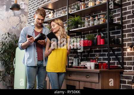 Beau couple wearing jeans le choix d'un plateau pour la soirée Banque D'Images