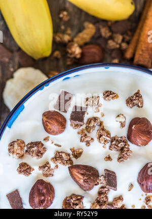 Servant de yaourt blanc avec du muesli, banane et noix Banque D'Images