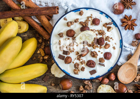 Servant de yaourt blanc avec du muesli, banane et noix Banque D'Images