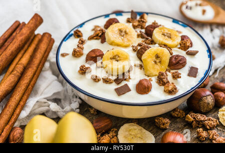 Servant de yaourt blanc avec du muesli, banane et noix Banque D'Images