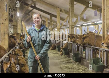 France, Savoie, hameau de navette, vallée de la Tarentaise, Julie Grataloup dans la ferme avec des vaches de race Tarine Banque D'Images