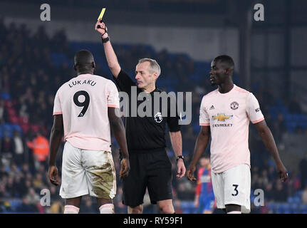 Londres, ANGLETERRE - 27 février 2019 : Anglais arbitre Martin Atkinson montre une carte jaune à Romelo Lukaku de Manchester au cours de la Premier League 2018/19 match entre Crystal Palace FC et Manchester United à Selhurst Park. Banque D'Images