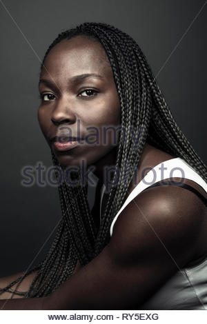 Portrait confiant belle jeune femme africaine avec de longues tresses noires