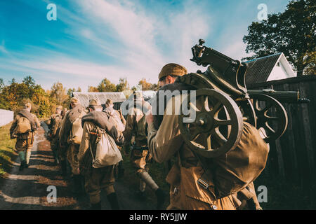 Groupe d'interprètes historiques habillé en russe de l'Armée rouge soviétique, les soldats d'infanterie de la Seconde Guerre mondiale, marchant marchant le long de route de campagne au village Russe Banque D'Images