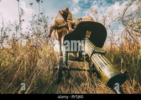 Reenactors habillés en soldats de l'Armée rouge soviétique russe de la Seconde Guerre mondiale la marche avec la mitrailleuse Maxim avec arme en automne Meadow Banque D'Images